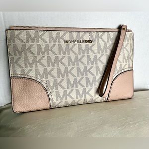 Gently used pink and white Michael Kors wristlet. 10” x 6”.